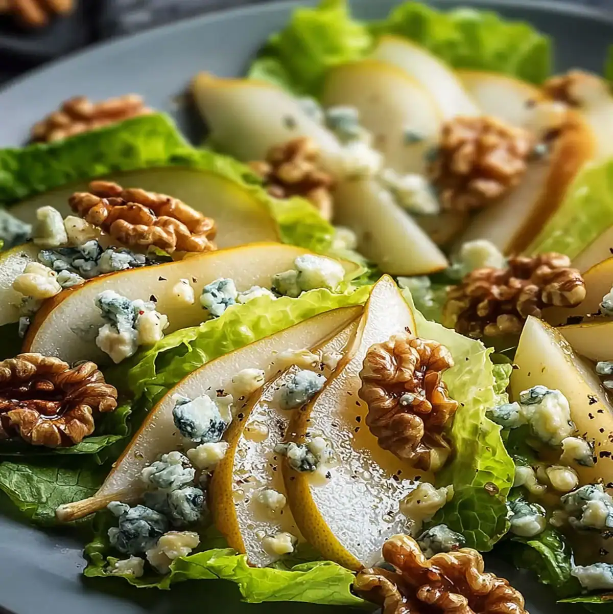 Fresh pear salad with crumbled blue cheese, walnuts, and honey drizzle