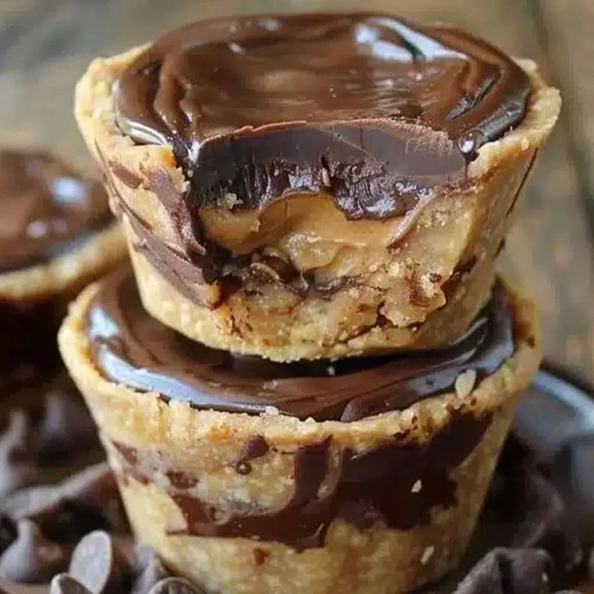 No-bake mini chocolate peanut butter pie topped with smooth chocolate ganache, stacked for a tempting dessert display.