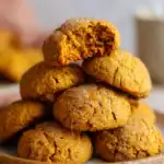 Chewy gluten-free pumpkin cookies stacked on a plate, rolled in coarse sugar with a soft, golden center.