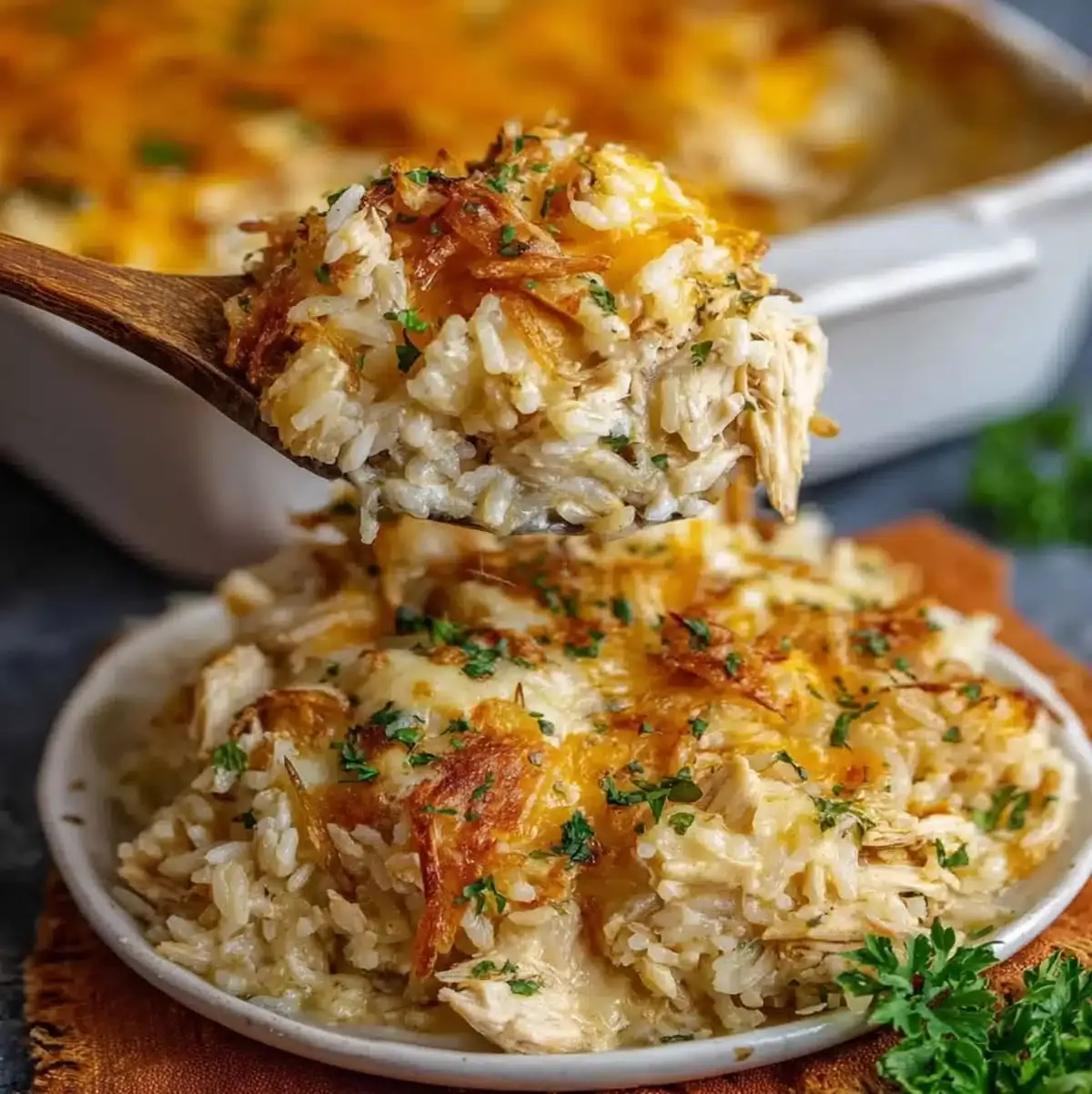 30-Minute French Onion Chicken 71 Close-up of creamy French Onion Chicken with rice, melted cheese, and caramelized onions on a wooden spoon
