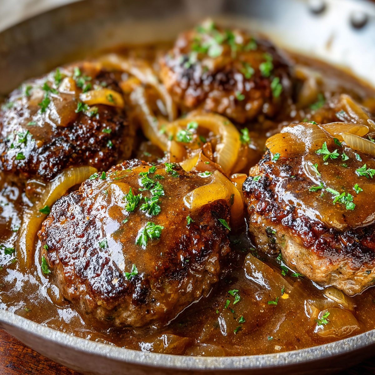 Hamburger Steak and Gravy – Easy Family Dinner Recipe 82 Hamburger steak and gravy cooking in a skillet with caramelized onions and rich brown sauce.