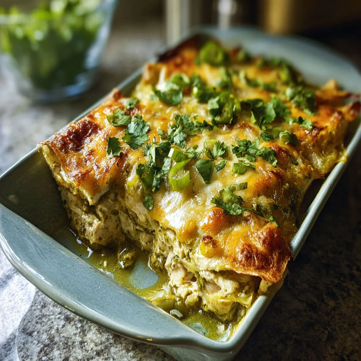 Green Chile Chicken Enchiladas – Easy Family Dinner 67 Green Chile Chicken Enchiladas in a baking dish, topped with cheese before broiling