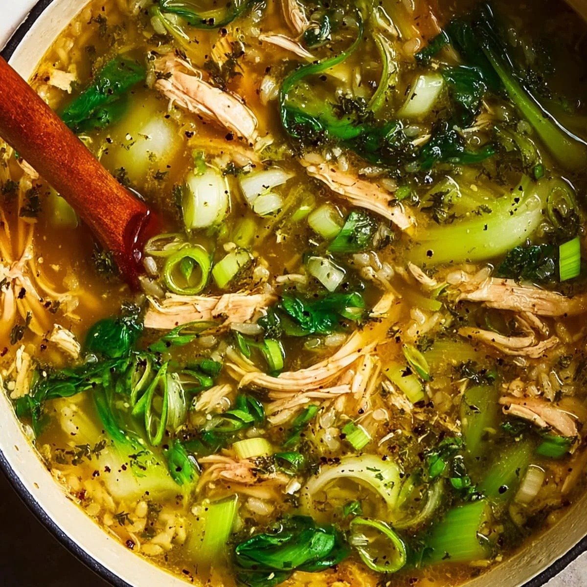 Ginger chicken and rice soup with shredded chicken, jasmine rice, and bok choy in golden broth