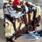 Hot Fudge Sundae Brownie Cheesecake with whipped cream, chocolate fudge drizzle, brownie crust, and cherry on top