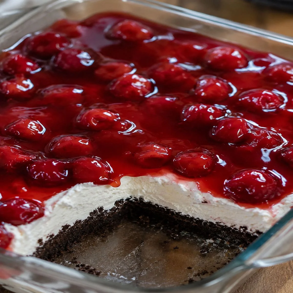 No Bake Cherry Cheesecake Dessert Recipe 59 No Bake Cherry Cheesecake Dessert Recipe in a glass baking dish with cherry pie filling, creamy cheesecake layer, and Oreo cookie crust.
